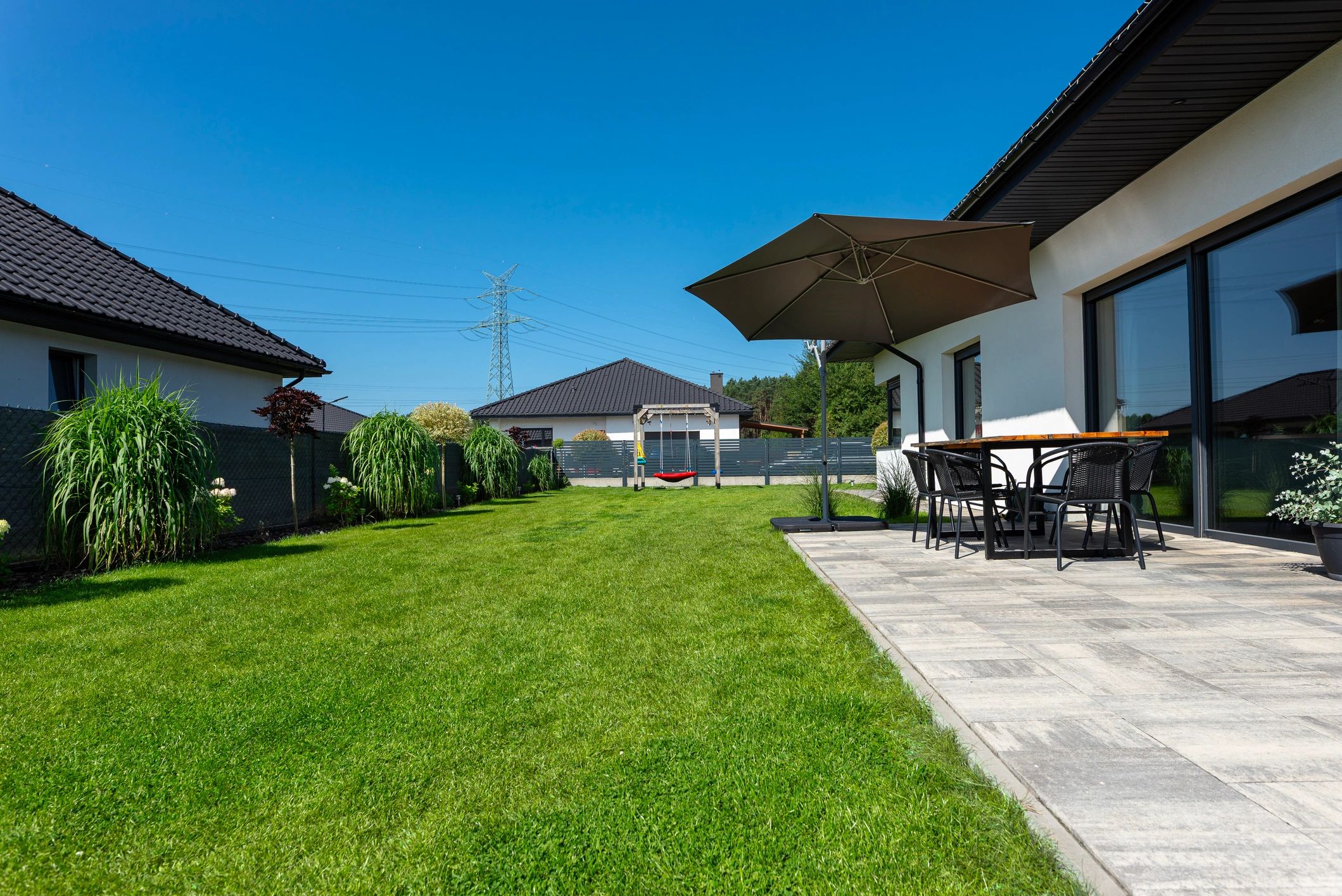 Manicured backyard garden with lush lawn and outdoor entertaining area
