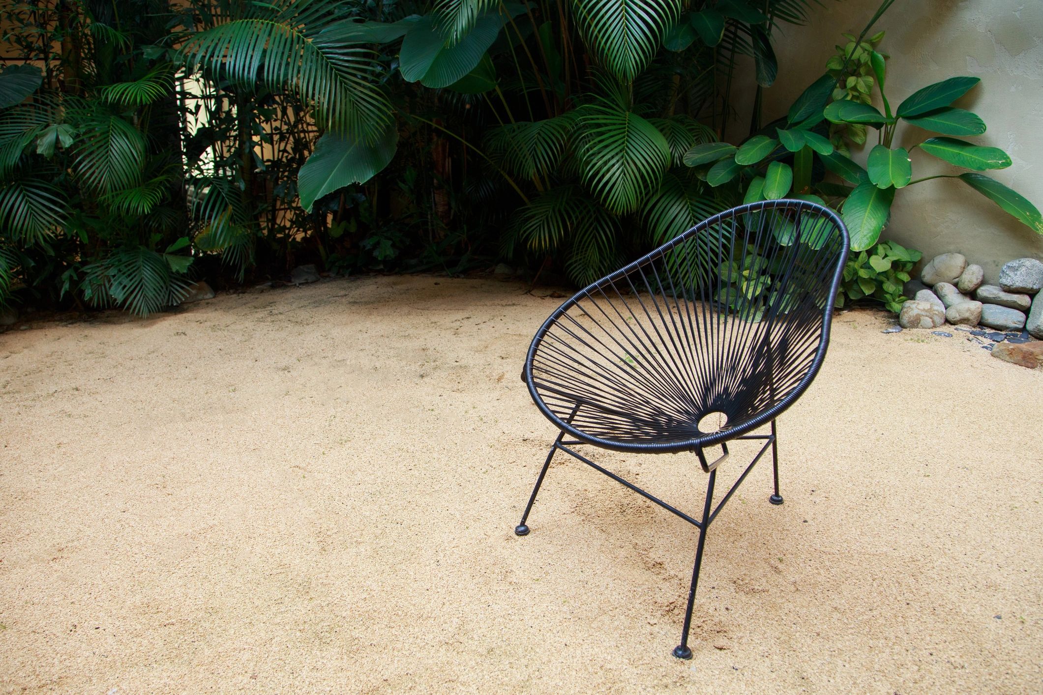 Stylish outdoor chairs in a landscaped garden setting